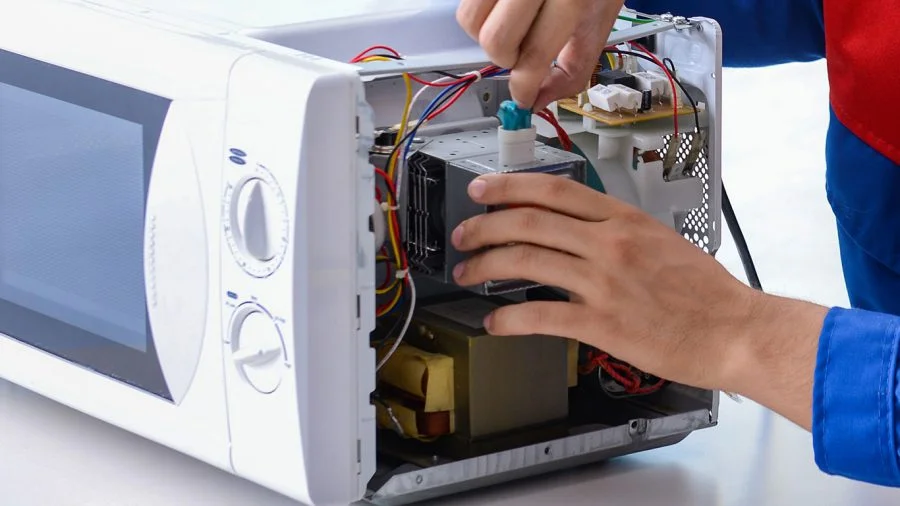Técnico especializado realizando conserto de microondas